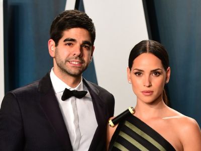 Edgardo Canales is wearing a tuxedo and Adria Arjona is wearing a one sleeveless dress with some roll design on it.